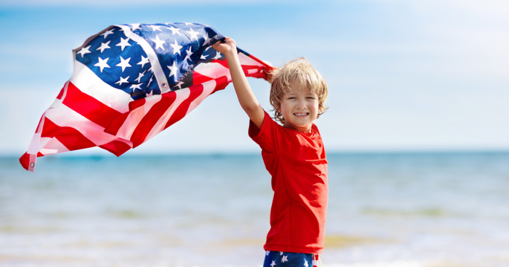 child on beach with american flag