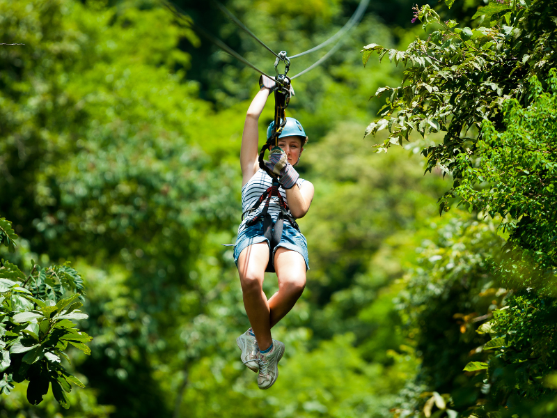 person ziplining through trees