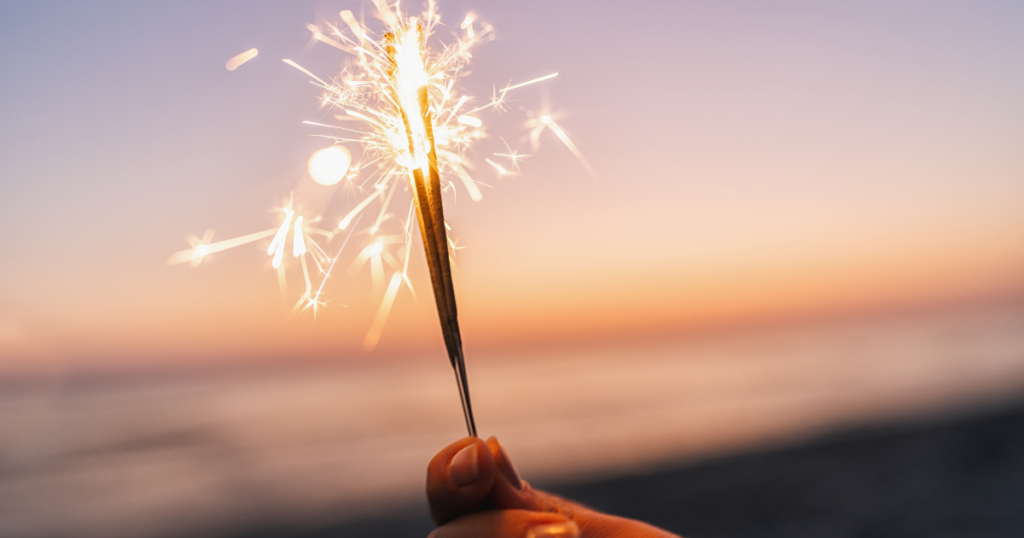 sparkler with beach in background
